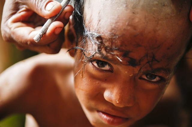 Một cậu bé được cạo tóc trong nghi lễ tôn giao tại một tu viện đạo Phật ở Bagan, Myanmar.