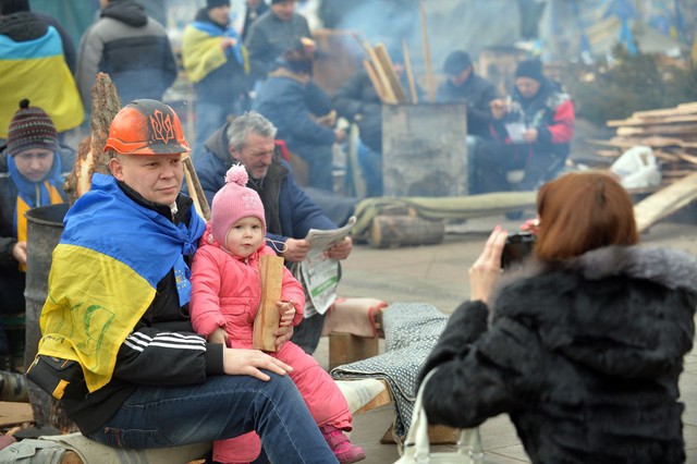 Một người biểu tình chụp ảnh với con gái trên quảng trường Độc lập ở Kiev, Ukraine.