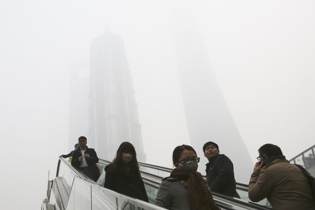 Mọi người di chuyển trên thang máy gần các tòa nhà chọc trời bị bảo phủ bởi sương mù ô nhiễm ở Thượng Hải, Trung Quốc.