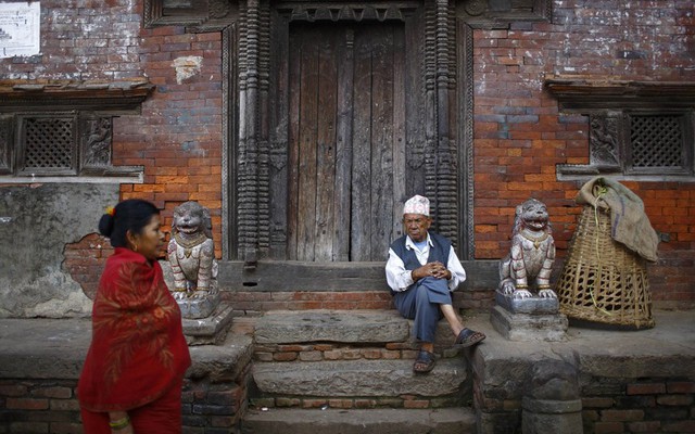 Người đàn ông ngồi trên cửa một ngôi đền tại thành phố cổ Bhaktapur, gần thủ đô Kathmandu, Nepal.