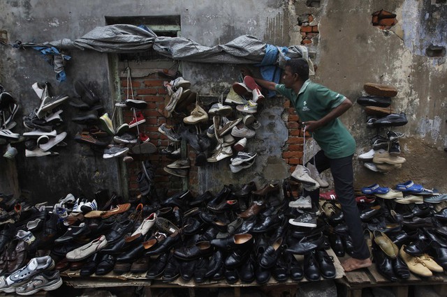 Một người ông bán giày trên hè phố ở Colombo, Sri Lanka.