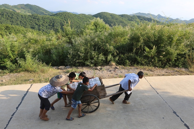 Người dân kéo xe chở nước tại thành phố Lâu Để thuộc tỉnh Hồ Nam, Trung Quốc.