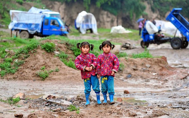 Hai bé gái sinh đôi đứng bên ngoài những túp lều tạm tại khu vực chịu ảnh hưởng bởi động đất ở thành phố Định Tây thuộc tỉnh Cam Túc, Trung Quốc.
