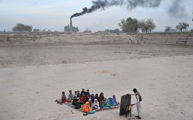 Trẻ em tham dự lớp học ngoài trời tại một tại tị nạn ở ngoại ô Jalalabad, Afghanistan.