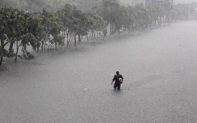 Một người đàn ông lội giữa đường phố ngập lụt ở thủ đô Manila, Philippines. Mưa lớn trong nhiều ngày đã khiến hơn 1/2 đường phố ở Manila biến thành sông.