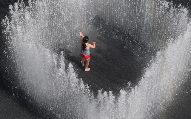 Một thiếu nữ chơi trong đài phun nước do nghệ sĩ người Đan Mạch Jeppe Hein thiết kế tại London, Anh.