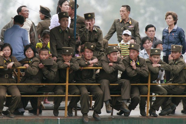 Các binh sĩ và người dân Triều Tiên ngồi trên phà để di chuyển qua sông Yalu ở thị trấn Sinuiju, gần biên giới với Trung Quốc.