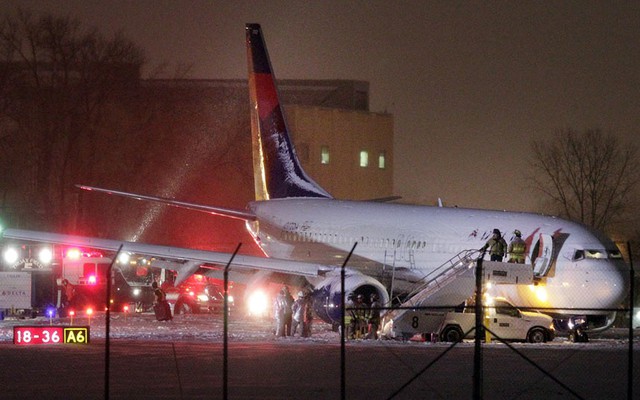 Các nhân viên an ninh đang kiểm tra hiện trường chiếc Boeing 737-800 của hãng hàng không Delta AirLines bị trượt khỏi đường băng tại sân bay ở Madison, Wisconsin, Mỹ.