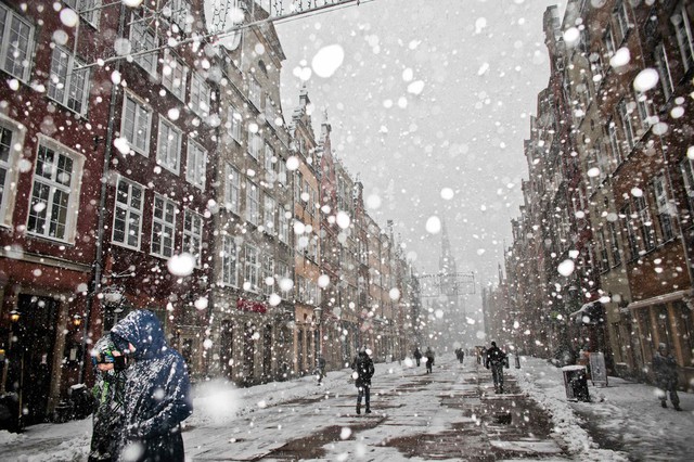 Mọi người đi dưới mưa tuyết trên đường phố ở Gdansk, Ba Lan.