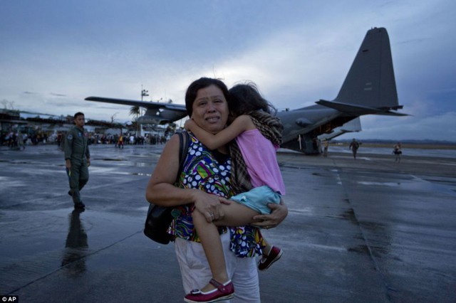 Một phụ nữ bế con gái vừa đi vừa khóc vì không kiếm được chỗ trên máy bay.