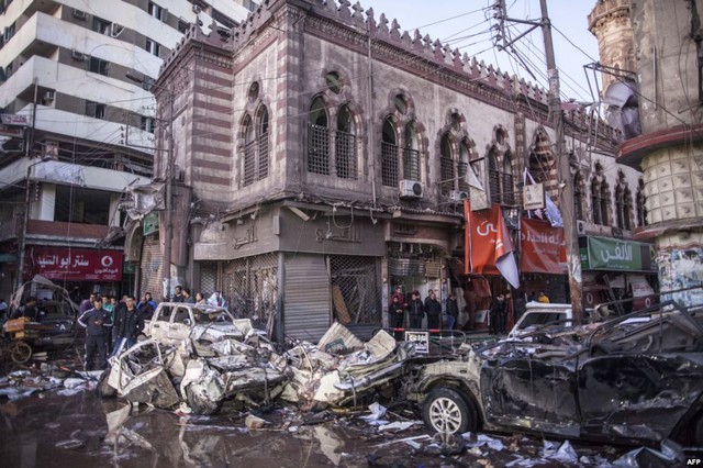 Mọi người kiểm tra thiệt hại tại hiện trường một vụ đánh bom ô tô ở thành phố Mansura, Ai Cập, khiến 14 người thiệt mạng.