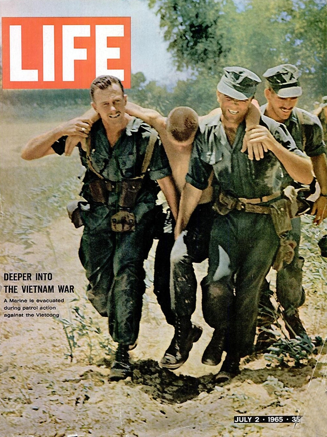 
	Lính thủy đánh bộ của Mỹ đang hỗ trợ một người đồng đội bị thương. Số ra ngày 2/7/1965.
