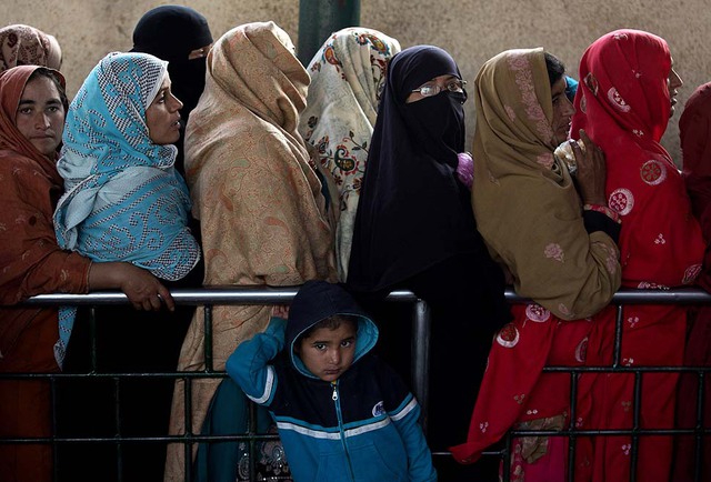Những phụ nữ người Pakistan xếp hàng chờ nhận thực phẩm phân phối tại một nhà thờ ở Islamabad.