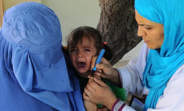 Bé gái khóc khi được nhân viên y tế tiêm vắc xin phòng chống bệnh bại liệt ở tỉnh Herat, Afghanistan.