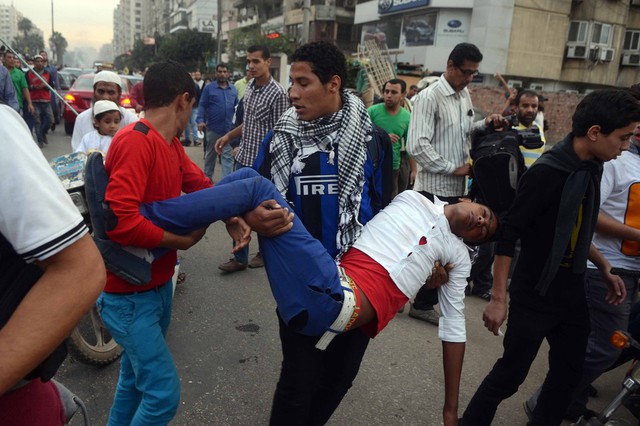 Những người ủng hộ Tổng thống Ai Cập bị phế truất Mohammed Morsi bế một người bị thương trong cuộc đụng độ với lực lượng an ninh gần quảng trường Rabaa Adawiya ở Cairo.