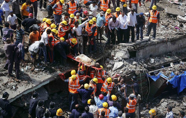 Các nhân viên cứu hộ dùng cáng đưa một nạn nhân khỏi đống đổ nát của một tòa nhà chung cư bị sập ở Mumbai, Ấn Độ.