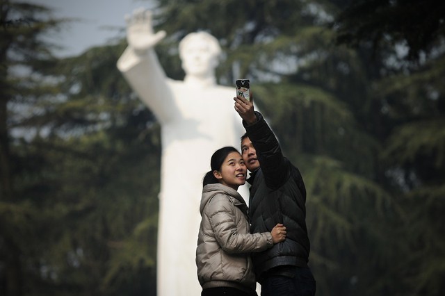 Một cặp đôi chụp ảnh trước tượng Mao Trạch Đông trong một công viên ở Thiền Sơn, Trung Quốc.