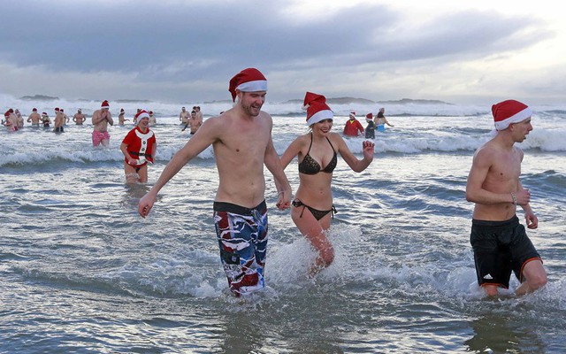Mọi người tham gia một sự kiện bơi dưới trời lạnh để gây quỹ từ thiện ở thị trấn Portrush, Bắc Ireland.