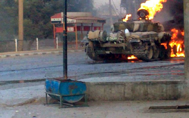 Một chiếc xe tăng của lực lượng quân đội chính phủ Syria bốc cháy trong cuộc giao tranh với lực lượng phiến quân ở ngoại ô thủ đô Damascus.
