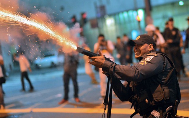 Cảnh sát chống bạo động bắn đạn hơi cay vào những công nhân biểu tình trên đường phố Rio de Janeiro, Brazil.