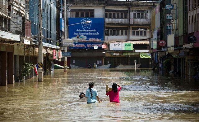 Hai cô gái lội trên đường phố ngập lụt tại tỉnh Kabin Buri, Thái Lan.