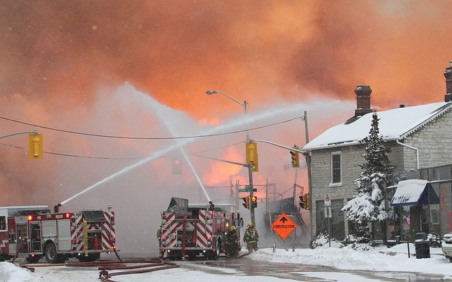 Lính cứu hỏa đang chiến đấu với một tòa nhà chung bốc cháy dưới trời mưa tuyết ở Kingston, Ontario, Canada.