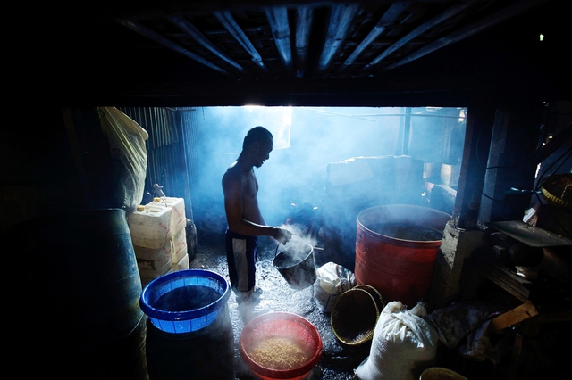 Một công nhân rửa những hạt đầu nành sau khi luộc tại một nhà máy sản xuất bánh đậu nành truyền thống ở Jakarta, Indonesia.