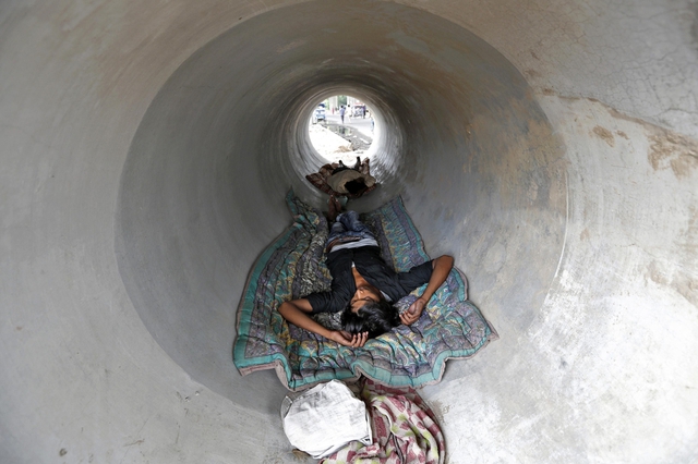 Mọi người ngủ trong đường ống bê tông để tránh nóng ở New Delhi, Ấn Độ.