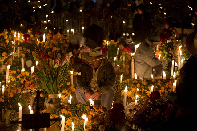 Một người đàn ông ngồi cầu nguyện bên mộ người thân trong ngày Day of the Dead ở Atzompa, Mexico.