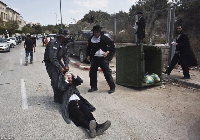 Cảnh sát Israel kéo một người Do Thái chính thống trong cuộc bạo loạn trên phố tại thị trấn Beit Shemesh, gần Jerusalem.