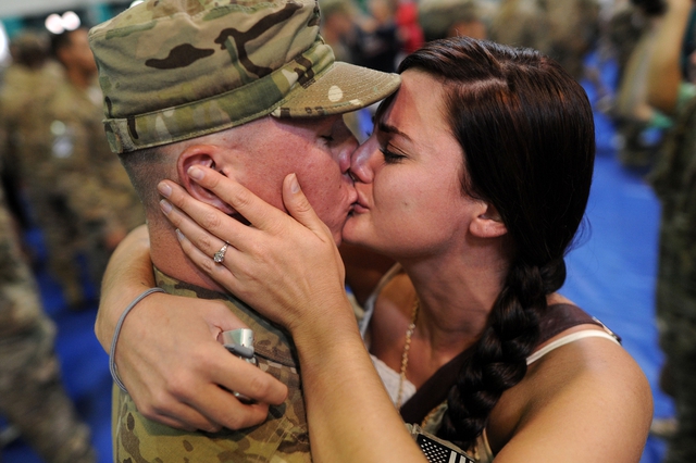 Một binh sĩ Mỹ hôn vợ thắm thiết khi trở về căn cứ quân sự Fort Stewart ở Georgia sau 9 tháng làm nhiệm vụ tại Afghanistan.