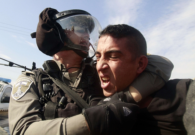 Một cảnh sát bảo vệ biên giới Israel bắt giữ người biểu tình Palestin phải đối khu định cư của người Do Thái ở Bờ Tây.