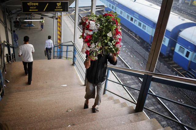 Một người đàn ông mang hoa đi bán tại ga tàu hỏa Dadar ở Mumbai, Ấn Độ.