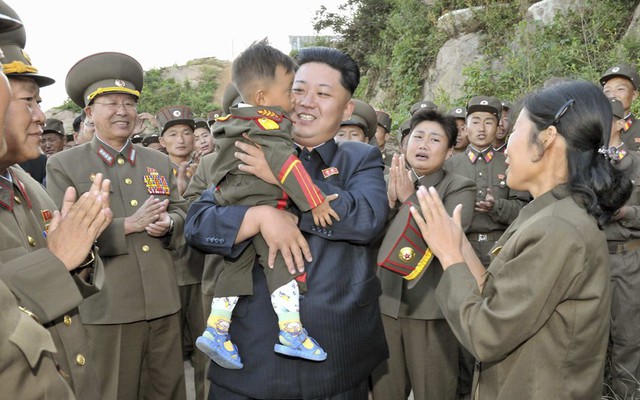 Nhà lãnh đạo Kim Jong-un bế một em bé trong khi kiểm tra đơn vị quân đội trên đảo tiền tiêu Jangjae, Triều Tiên.