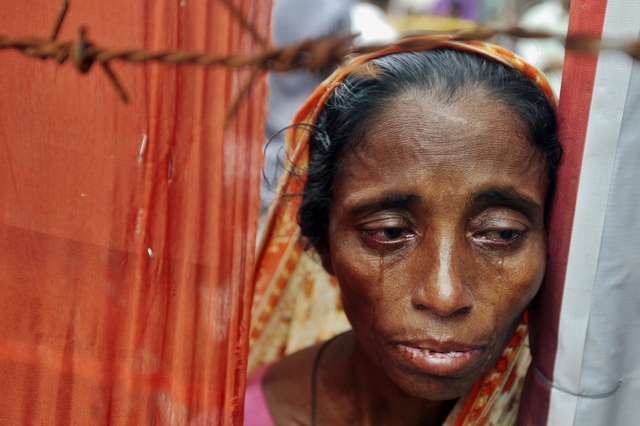 Một phụ nữ khóc cạnh đống đổ nát của tòa nhà Rana Plaza ở Dhaka, Bangladesh.  Tòa nhà Rana Plaza bị sập vào tháng 4 vừa qua khiến 1.129 người thiệt mạng.