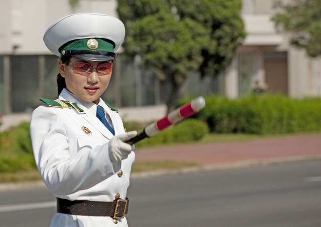 Nữ cảnh sát giao thông điều khiển tại một ngã tư đường phố ở Bình Nhưỡng, Trung Quốc.
