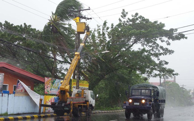 Các binh sĩ đang sơ tán người dân trong khi công nhân sửa đường điện khi bão Haiyan đi qua thành phố Legazpi, tỉnh Albay.