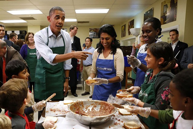Tổng thống Mỹ Barack Obama chào trẻ em và những người tình nguyện khi tới thăm bếp từ thiện Martha's Table ở thủ đô Washington.