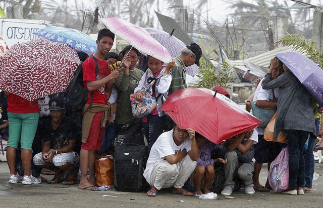 Những người sống sót sau siêu bão Haiyan mỏi mỏi xếp hàng chờ máy bay để sơ tán khỏi thành phố Tacloban, Philippines.