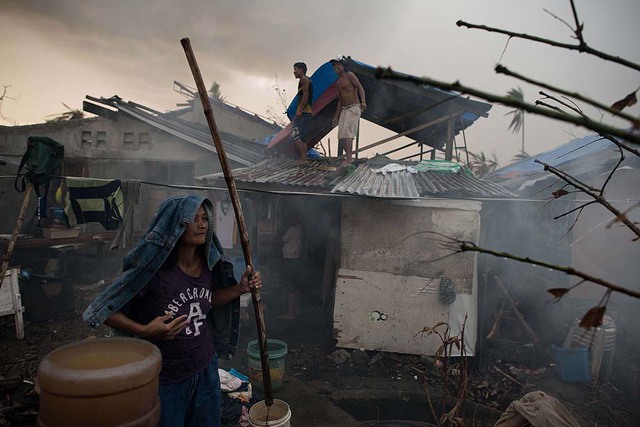 Các nạn nhân sống sót sau siêu bão Haiyan đang xây dựng những ngôi nhà tạm ở Palo, Philippines.