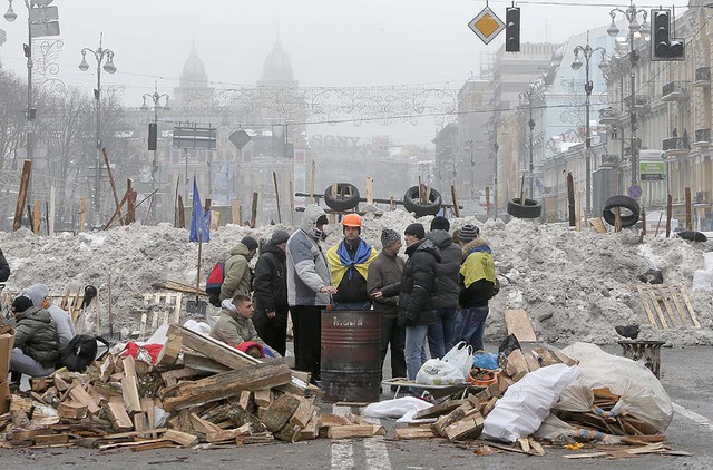 Người biểu tình sưởi ấm trong khi bảo vệ hàng rào trên đường phố Khreschatyk ở Kiev, Ukraine.