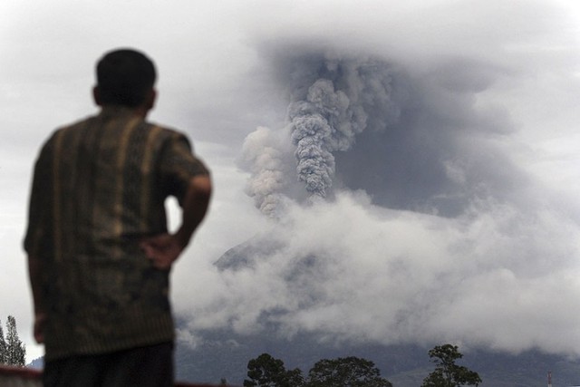 Một người đàn ông nhìn núi lửa Sinabung phun trào tro bụi tại Gundaling, North Sumatra, Indonesia.