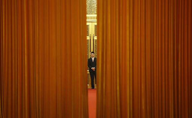 Một nhân viên an ninh đứng trước cửa phòng nơi diễn ra cuộc họp giữa Phó tổng thống Brazil  Michel Temer và Chủ tịch Trung Quốc Tập Cận Bình ở thủ đô Bắc Kinh.
