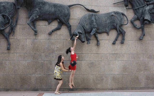 Một thiếu nữ cố gắng đu trên một bức tường bên ngoài đầu trường bò tót ở thủ đô Madrid, Tây Ban Nha.