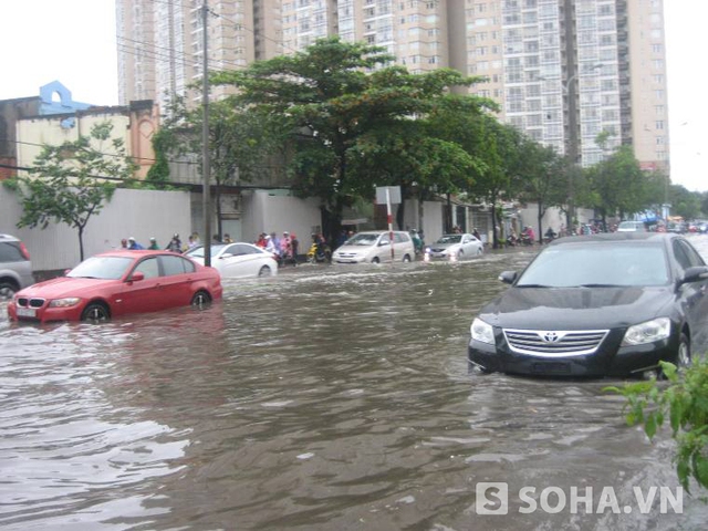 TP.HCM mưa lớn, cột điện đổ, ô tô trôi trên đường