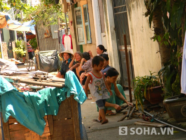Những người dân trong hẻm 108, đường Lê Văn Lương, phường Tân Hưng, quận 7 tụ tập bàn tán về số phận của cháu bé 3 tuổi bị bạo hành