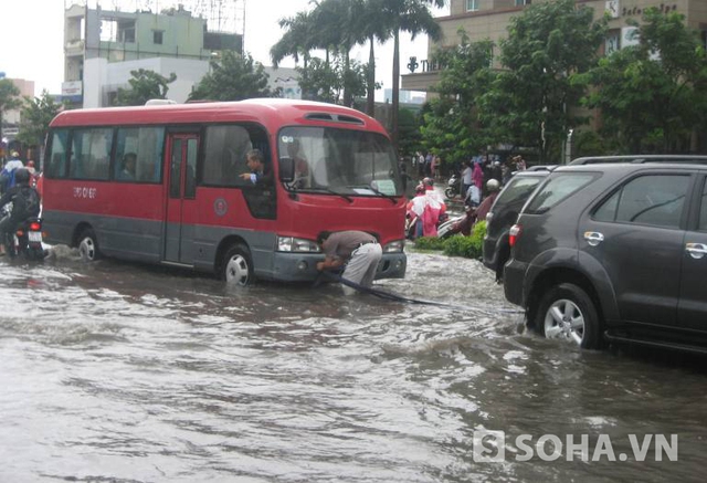 TP.HCM mưa lớn, cột điện đổ, ô tô trôi trên đường