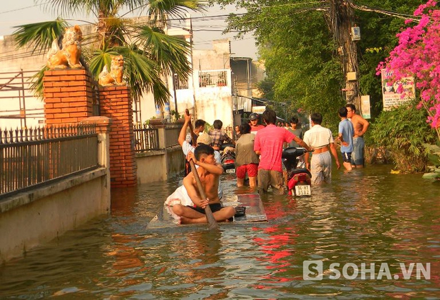 Người dân dùng bè gỗ di tản đồ đạc người già và trẻ nhỏ đến nơi an toàn