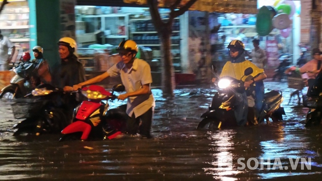 Nhiều người phải bì bõm dắt xe trong dòng nước đen