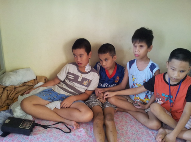 Những trẻ em mù lặng ngồi bên nhau nghe đài để tưởng tượng về cụ Võ Nguyên Giáp.